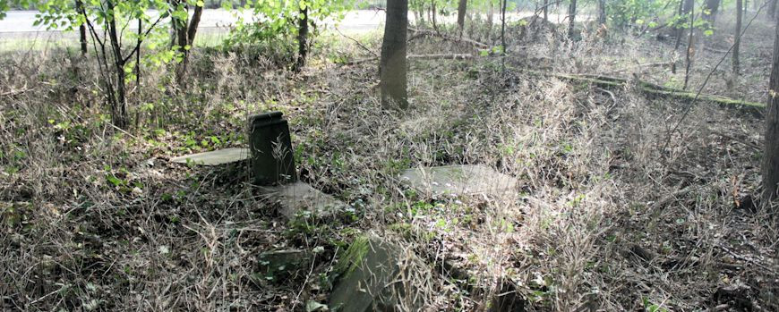 Umgekippte Grabsteine und Fragmente des Friedhofes an der Fernverkehrsstraße